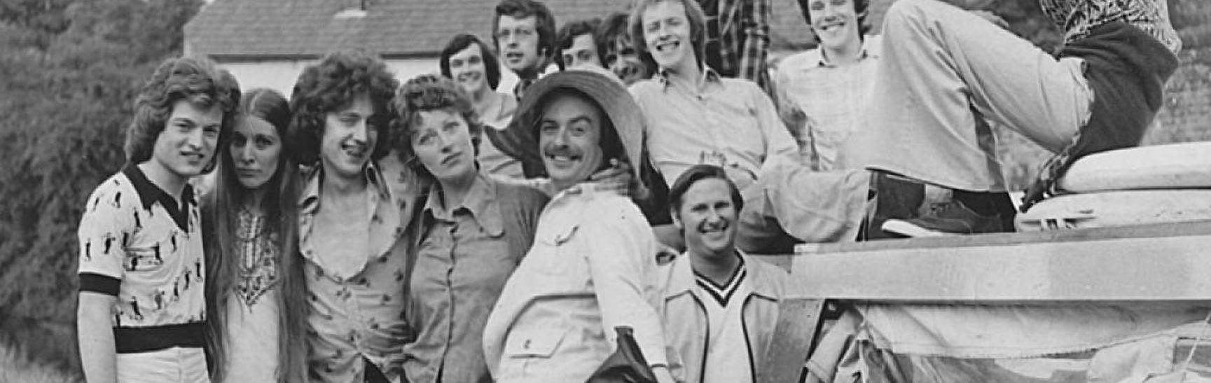 black and white photo of a group of young people posing in fashionable 1970s outfits.