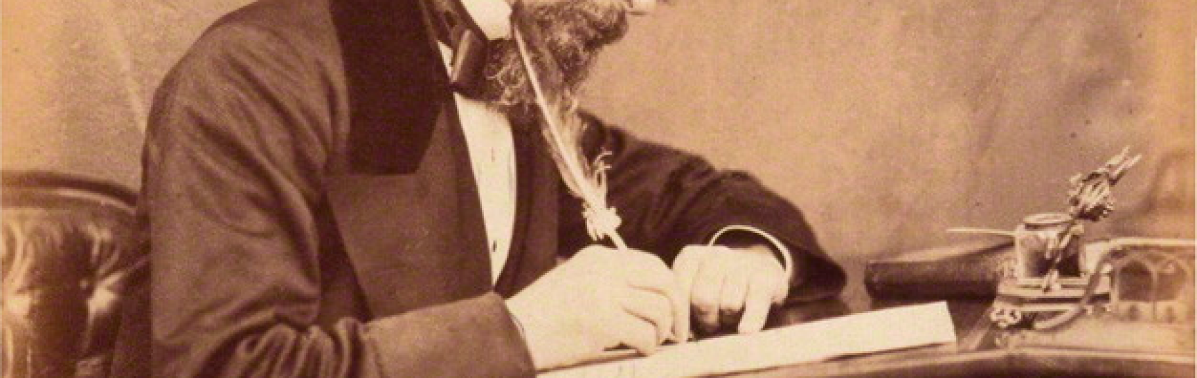 photo of charles dickens at a writing desk