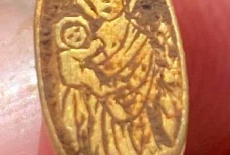 photo of gold ring with etching of woman and baby