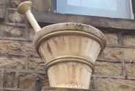 photo of chemist's shop sign in the form of a large model pestle & mortar.